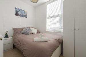 Un dormitorio con una cama con una toalla blanca. en Denebank Lodge - Anfield Apartments, en Liverpool