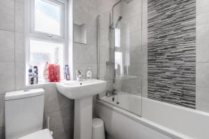 W łazience znajduje się umywalka, toaleta i wanna. w obiekcie Denebank Lodge - Anfield Apartments w Liverpoolu