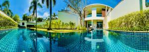 a house with a swimming pool in front of it at White Lotus by Oxygen at Bang Tao Beach in Ban Thalat Choeng Thale