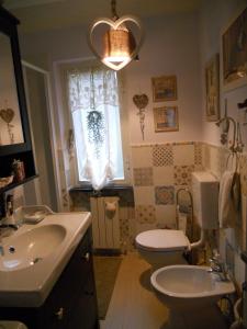 a bathroom with a sink and a toilet and a window at La casa azzurra in Moneglia