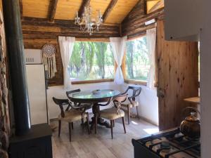 a dining room with a table and chairs and a window at FINCA LA PAZ in Uspallata