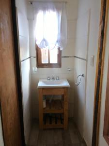 un piccolo bagno con lavandino e finestra di FINCA LA PAZ a Uspallata