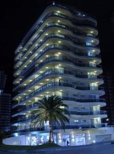 un gran edificio con una palmera delante en Sol y Luna Home&Spa, en Punta del Este