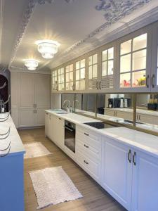 a large kitchen with white counters and white cabinets at Villa Brezovica near skiing center in Brezovicë