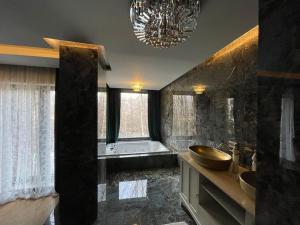a large bathroom with a sink and a chandelier at Villa Brezovica near skiing center in Brezovicë +42 photos