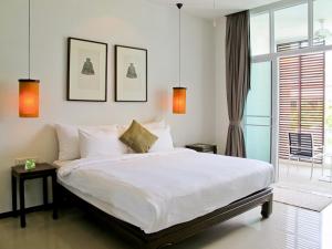 a bedroom with a large white bed and a window at White Lotus by Oxygen at Bang Tao Beach in Ban Thalat Choeng Thale +64 photos