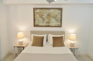 a bedroom with a large white bed with two lamps at Mirador Catedral de Santiago in Bilbao