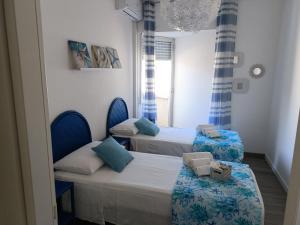 Dos camas en una habitación con azul y blanco. en Villa Marthan, en San Vito lo Capo