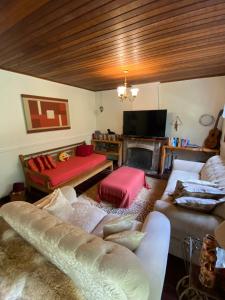 sala de estar con sofá y chimenea en Apartamento em Condomínio Campos do Jordão, en Campos do Jordão