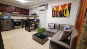 sala de estar con sofá y cocina en Mimos Le café, en Machala