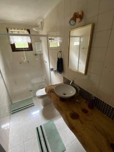 y baño con lavabo, aseo y espejo. en Apartamento em Condomínio Campos do Jordão, en Campos do Jordão