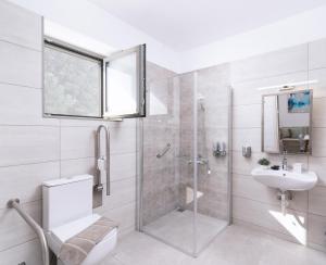 a bathroom with a shower and a toilet and a sink at Matala Prime Villas in Matala