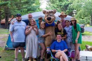 un grupo de personas posando para una foto con un disfraz de oso en Yogi Bear's Jellystone Park Camp-Resort Wisconsin Dells en Wisconsin Dells