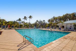 a swimming pool in a resort with chairs and palm trees at Tavernier Escape #4408 in Tavernier