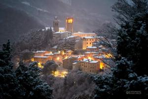 una piccola città su una collina di notte di Casa Coccinella a Nocera Umbra