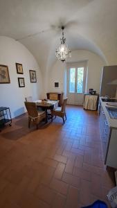 a living room with a table and chairs and a chandelier at Dépendance in Villa Albachiara in Carmignano
