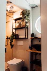 un bagno con servizi igienici e alcune piante sul muro di Stay at Smilla - Boutique Apartments mit Küche - Parken - Klima - Netflix - Waschmaschine a Wiesbaden