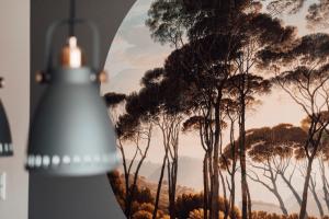 a mirror with a picture of trees in the background at Stay at Smilla - Boutique Apartments mit Küche - Parken - Klima - Netflix - Waschmaschine in Wiesbaden