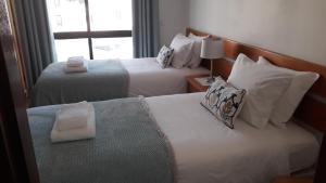 a hotel room with two beds and a window at Salema Beach Apartment in Salema