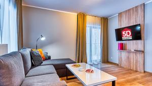 a living room with a couch and a table at Apartament 28 z Basenem i SPA - 5D Apartments in Szklarska Poręba