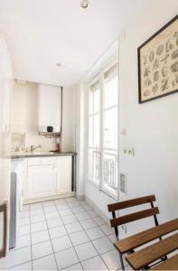 a kitchen with a bench and a table and a window at SUITE ELISE Passy in Paris