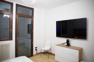 ein Schlafzimmer mit einem TV an einer weißen Wand in der Unterkunft SWEET HOUSE MEDA in Mailand