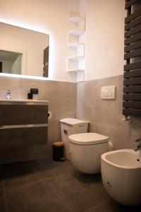 ein Badezimmer mit einem WC, einem Waschbecken und einem Spiegel in der Unterkunft SWEET HOUSE MEDA in Mailand