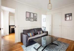 - un salon avec un canapé et une table en verre dans l'établissement SUITE ELISE Passy, à Paris