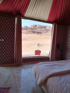 a bedroom with a bed and a view of the desert at The sunset of Wadi Rum in Wadi Rum