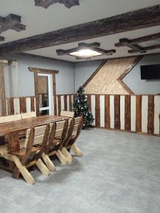 a room with a christmas tree and a table and benches at Кольорові подорожі 2 in Slavske