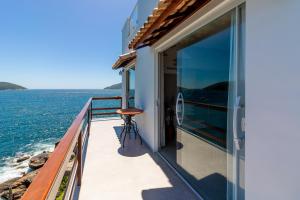 a balcony of a house with a view of the ocean at Villa Orion in Arraial do Cabo