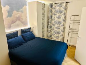 a blue bed in a room with a painting at Home Sweet Home Champs de Mars in Paris