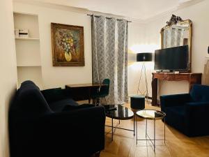 a living room with a couch and a tv at Home Sweet Home Champs de Mars in Paris