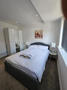 um quarto com uma cama grande e lençóis brancos em Hazel 1-Bed Flat (2) + Parking em Kidlington