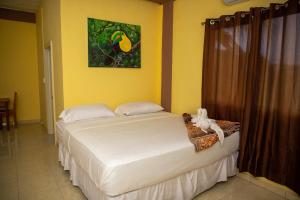 2 camas en una habitación con paredes amarillas en La Cascada Stays en San Ignacio