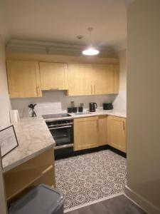 uma cozinha com armários de madeira e um forno com placa de fogão em Foyle View Apartment em Derry