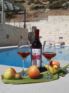 a bottle of wine and two glasses on a table at Matala Prime Villas in Matala