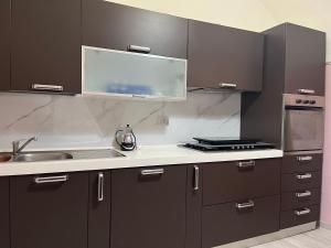 a kitchen with dark brown cabinets and a sink at Casa vacanza Pratola in Pratola Peligna