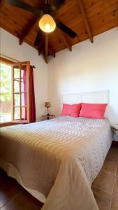 1 dormitorio con 1 cama grande con almohadas rojas en Los Teritos en Tandil