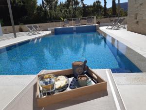a tray of food sitting next to a swimming pool at Matala Prime Villas in Matala