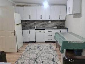 - une cuisine avec des placards blancs, une table et un réfrigérateur dans l'établissement Bahçeli büyük köy evi, à Fethiye