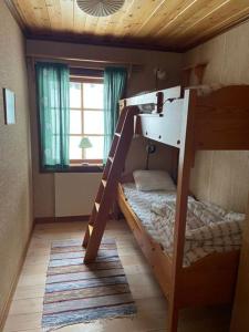 1 Schlafzimmer mit 2 Etagenbetten und einem Fenster in der Unterkunft Baggården Messlingen Fjällstuga in Messlingen