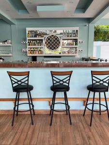 a bar with three chairs in front of a counter at La Cascada Stays in San Ignacio