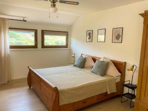 a bedroom with a large wooden bed with two pillows at Boutique Guesthouse Das WOHLGEMUTH HEIM Mosel Weingut in Zell an der Mosel