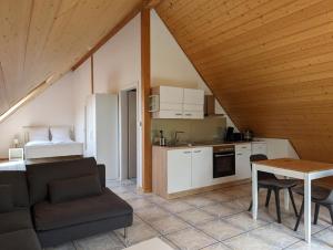 cocina y sala de estar con sofá y mesa en Ferienwohnung am Schönberg - Ebringen, en Ebringen