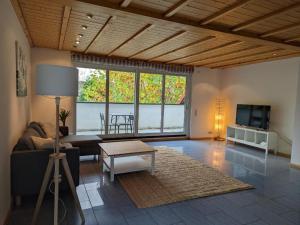 a living room with a couch and a table and a tv at Ferienwohnung am Schönberg - Ebringen in Ebringen