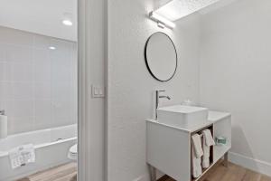 a white bathroom with a sink and a mirror at Baymont by Wyndham Jacksonville Airport in Jacksonville +27 photos