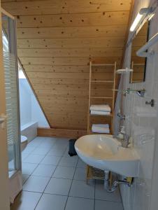 baño con lavabo y techo de madera en Ferienwohnung am Schönberg - Ebringen, en Ebringen