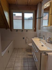 y baño con 2 lavabos, bañera y aseo. en Ferienwohnung am Schönberg - Ebringen, en Ebringen