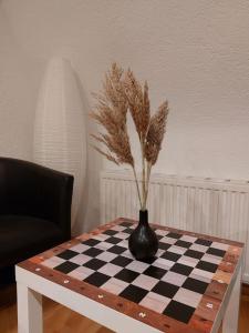 a black vase sitting on a chess board on a table at Rooftop Apartmens Ulm - komfortable neue Gemeinschaftsunterkunft im Herzen von Ulm - Raum 2 in Ulm
